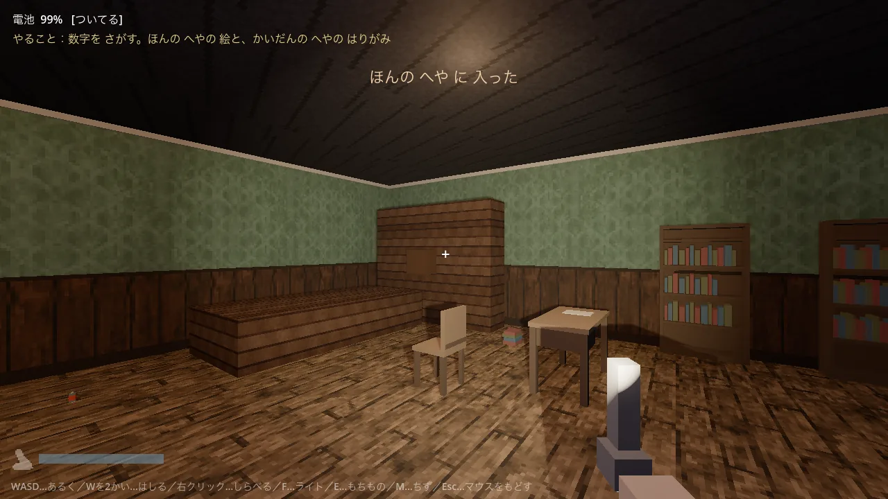 本棚と机のある部屋の全景。明かりがついていて隅々まで見渡せる